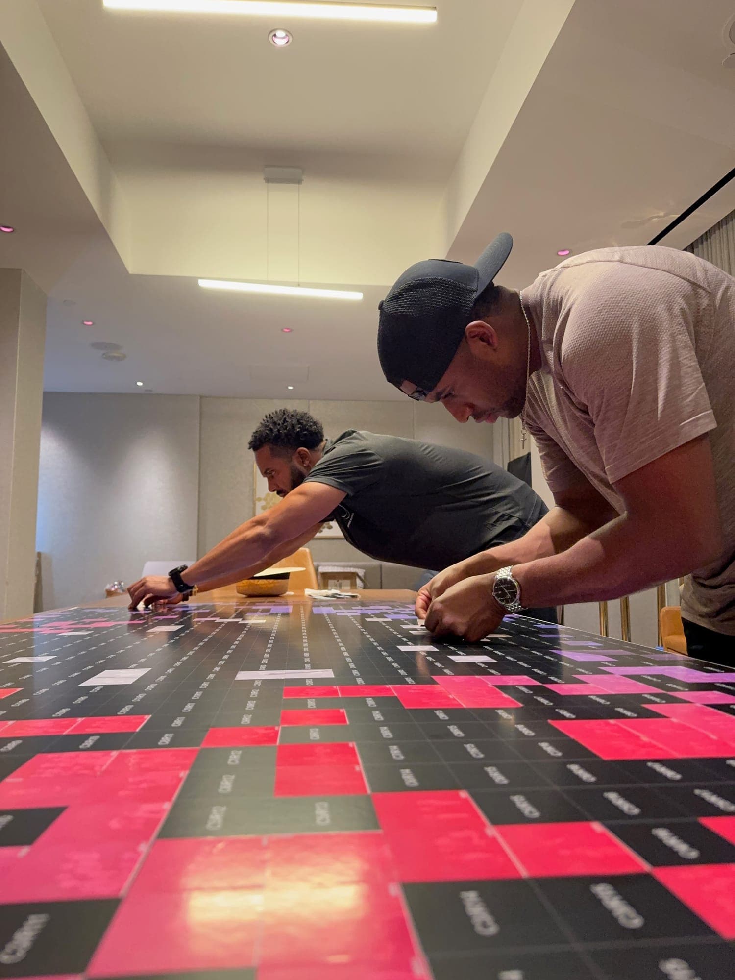 Two of the founders building the mosaic wall on a table