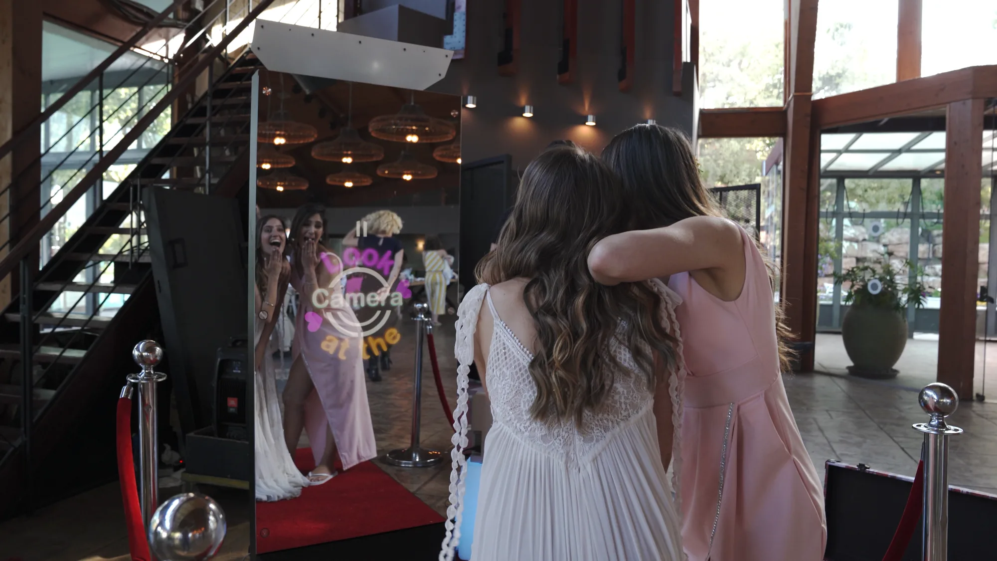 Two guests at a Mirror X booth on a red carpet